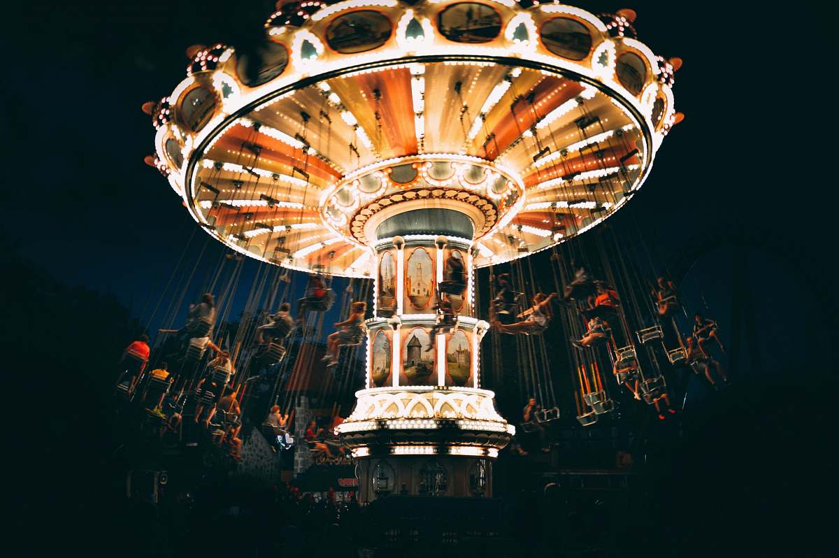 theme park people riding revolving carnival ride during night chandelier